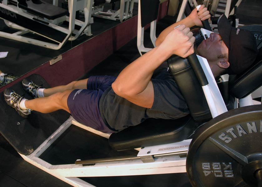 Tips: Lie face up on a hack squat machine with shoulders against pad.Place ...