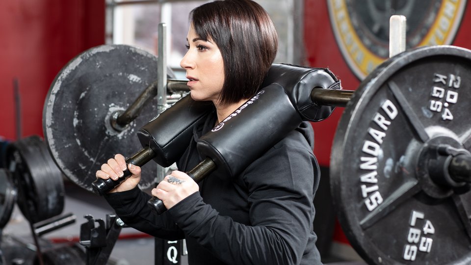 woman using a safety squat barbell