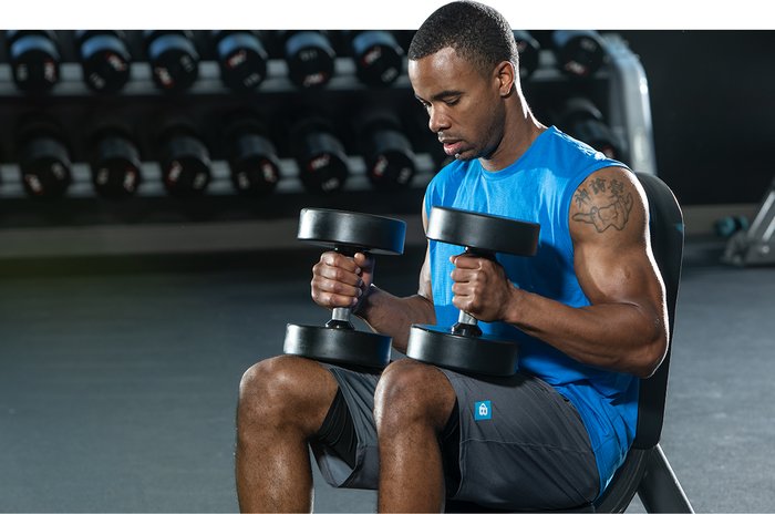 Taking a rest with dumbbells in the gym. 