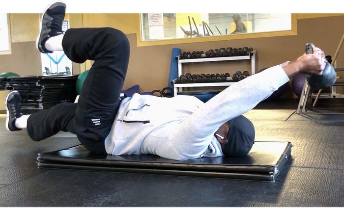 Working out with a kettlebell on a mat.