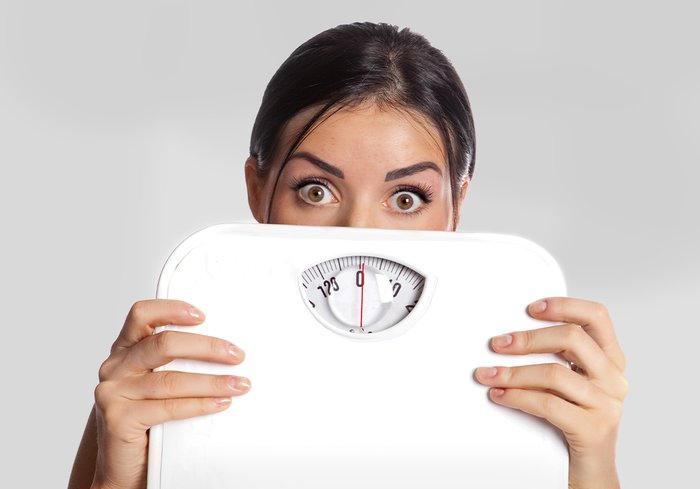 A woman holding a scale. 