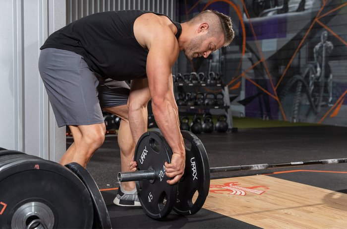 Loading weights on a barbell. 