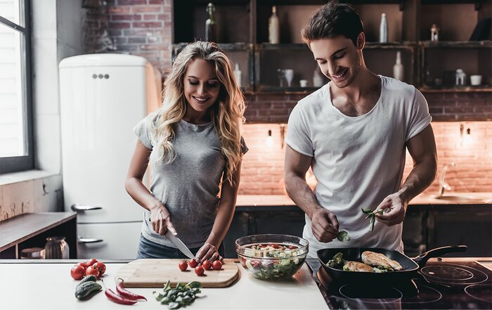 A couple cooking a meal together. 