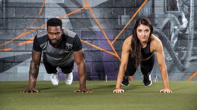 Female athletes show off their toned bodies as they stand back to back in a  studio