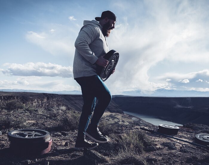 Clay Cooper loading his weights outdoors