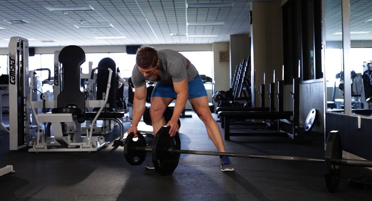 Loading weight plates on a barbell.